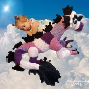 May include: A large crocheted purple and white striped dragon with black accents. The dragon has a long tail and multiple legs. The dragon is lying on its side with its head turned to the side. The dragon is in front of a blue sky with white clouds.