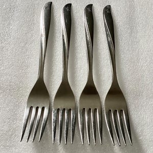 May include: Four silver forks with a star design on the handle.