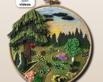 May include: A circular wooden embroidery hoop containing a landscape scene with a large textured green tree, a winding path, colorful floral patches, a forest line, and a yellow sun against a light blue sky. Text reads PDF pattern with videos.