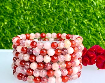 May include: A stack of six bracelets made with red carnelian, pink rose quartz, and clear quartz beads.