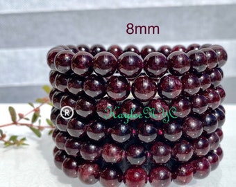 Puede incluir: Cinco pulseras de granate apiladas, cada una con cuentas de 8 mm. Las pulseras son de color rojo intenso y tienen un acabado brillante.