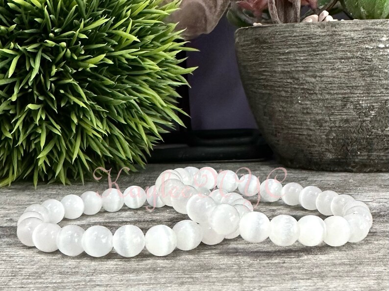 Puede incluir: Dos pulseras de piedras preciosas blancas con cuentas redondas. Las pulseras est&aacute;n hechas de cuentas de piedra lunar blanca.