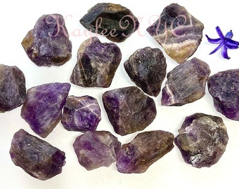 May include: A collection of 12 amethyst rough stones, each with a unique shape and size. The stones are a deep purple color with some natural inclusions.