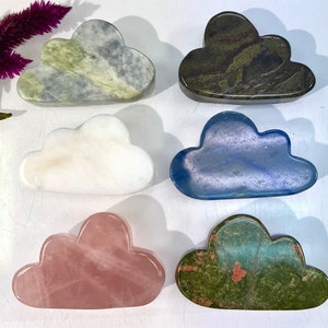 Könnte beinhalten: Sechs wolkenförmige, polierte Steine in verschiedenen Farben, darunter Grün, Weiß, Blau, Rosa und ein dunkleres Grün mit roten Flecken. Die Steine sind in zwei Reihen zu je drei angeordnet.