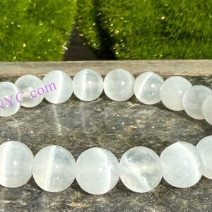 Puede incluir: Pulsera de piedras preciosas blancas con cuentas redondas. La pulsera est&aacute; hecha de piedras blancas con un ligero brillo iridiscente.