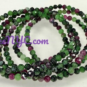 May include: Strands of faceted gemstone beads in shades of green, dark green, and burgundy. The beads are strung together to form multiple bracelets. The image includes the text "KayleeNiya.com".