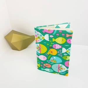 Familieboekje of paspoorthoes, boekjehoes. Veelkleurige vispatronen op een groene achtergrond, smaragdgroene driehoeken