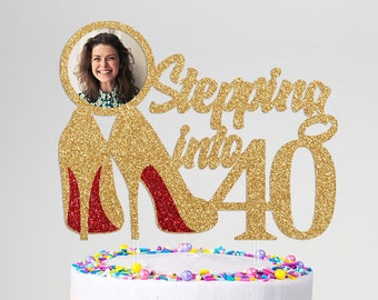May include: A gold glitter cake topper with the text "Stepping into 40". The topper features a photo in a circular frame, and two high heels with red soles. The cake is decorated with colorful sprinkles.