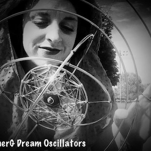 May include: Monochrome image featuring a person interacting with a complex metal sculpture. The sculpture has a central spherical component and radiating circular and linear elements. The text "innerG Dream Oscillators" is visible.