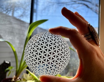 Specchio sferico artigianale con incisione del Fiore della Vita: decorazione ispirata alla geometria sacra.