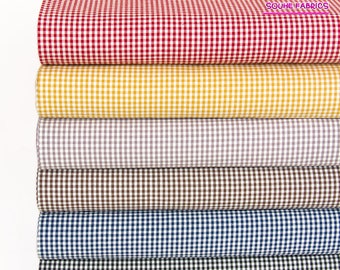 May include: Six rolls of gingham fabric in various colors, including red, yellow, gray, brown, blue, and black. The fabric has a small checkered pattern.
