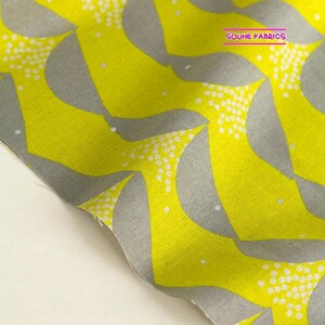 May include: Yellow fabric with a gray and white geometric pattern. The pattern features repeating curved shapes with white dots.