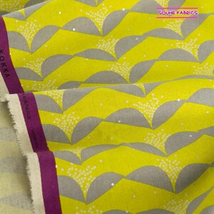 May include: Yellow fabric with a gray and white geometric pattern. The fabric has a subtle sheen and is perfect for quilting, sewing, and crafting.