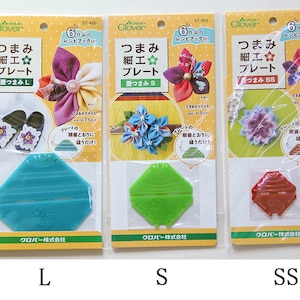 以下が含まれることがあります： 布花を作るためのプラスチック製のテンプレート3枚。テンプレートはL、S、SSとラベル付けされています。テンプレートはターコイズ、グリーン、レッドです。パッケージには、テンプレートを使用して作られた布花の例が示されています。
