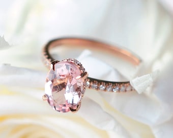Op de afbeelding: Een verlovingsring van roségoud met een roze ovale edelsteen en een band met kleine diamanten.
