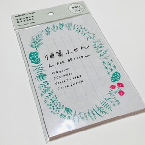 May include: A package of sticky notes with a white background and a decorative border of green and red floral illustrations. The notes are lined and include text in Japanese and English, with dimensions of 85 x 137 mm.