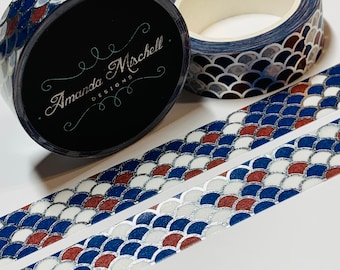 May include: Two rolls of washi tape with a blue, white, and red scale pattern. The tape is on a white background. The tape is labeled "Amanda Mischell Designs."
