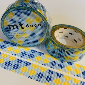 May include: Two rolls of mt deco washi tape with a blue, yellow, and white diamond pattern. The rolls are partially unwound, revealing the adhesive tape. The packaging includes the text "mt deco" and "kamoi paper washi adhesive tape."