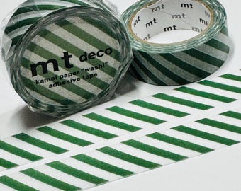 Puede incluir: Dos rollos de cinta adhesiva washi mt deco con rayas diagonales verdes y blancas. Un rollo está parcialmente desenrollado, revelando la cinta adhesiva. El texto "mt deco kamoi paper washi adhesive tape" está impreso en el rollo.