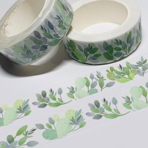 May include: Two rolls of decorative washi tape with a botanical design. The tape features green leaves and light green cactus illustrations on a white background. Two strips of the tape are unrolled, showing the repeating pattern.