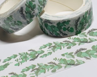 May include: Two rolls of green and white washi tape with a leafy pattern. The tape is unrolled and shows the pattern.