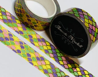May include: Two rolls of washi tape with a mermaid scale pattern in shades of green, purple, pink, and yellow with gold glitter accents. The tape is unrolled to show the pattern. The rolls are labeled "Amanda Mischell Designs."
