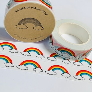 May include: A roll of rainbow washi tape with a white background and a repeating pattern of rainbows and clouds. The tape is labeled "Rainbow Washi Tape" and "15mm x 10m - Acid-Free".