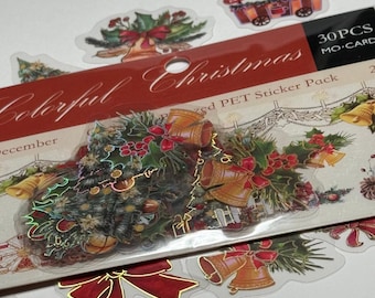 May include: A pack of 30 PET stickers with a Christmas theme. The stickers feature images of Christmas trees, bells, bows, and a train. The packaging has the words "Colorful Christmas" in a decorative font.