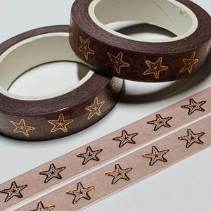 May include: Two rolls of brown washi tape with gold starfish designs, and two strips of pink washi tape with gold starfish designs. The tape is ideal for scrapbooking, journaling, and other craft projects.
