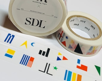 May include: Two rolls of mt masking tape. One roll has the text "mt masking tape" and "SDL" printed on it. The other roll has colorful geometric shapes. Strips of tape with various geometric designs are also visible.