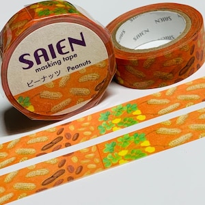 May include: Two rolls of masking tape with a peanut design. The tape is orange with illustrations of peanuts and green foliage. One roll has the word "SAIEN" in purple and the words "masking tape" and "Peanuts" in black.