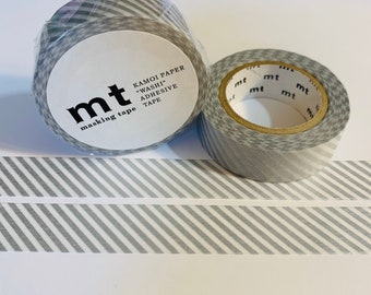 Puede incluir: Dos rollos de cinta washi a rayas grises y blancas con la marca "mt masking tape" y el texto "Kamoi Paper "Washi" Adhesive Tape" impreso en la etiqueta.
