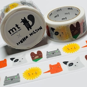 May include: Two rolls of mt masking tape featuring whimsical animal designs. One roll is wrapped in plastic and has the text "mt masking tape x DONNA WILSON". The other roll displays various animal faces. A strip of tape with repeating animal and sun illustrations is also visible.