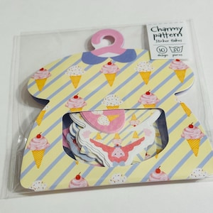 May include: A package of sticker flakes in a dress-shaped container. The container is yellow with blue stripes and ice cream cone illustrations. The package includes 30 design pieces and the text "Charmy pattern".
