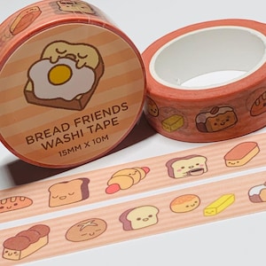 May include: Two rolls of "Bread Friends" washi tape. The tape is orange with a repeating pattern of bread-themed illustrations. One roll features a large graphic of a fried egg on toast. The tape is 15mm wide and 10 meters long.