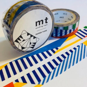 May include: Two rolls of washi tape with geometric patterns in blue, yellow, and white. The tape is labeled "mt masking tape PAPIER TIGRE".