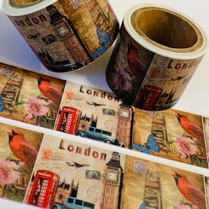 May include: Two rolls of decorative washi tape featuring a vintage London theme. The tape design includes images of Big Ben, red telephone booths, classic cars, and red birds. The word "London" is printed on the tape.