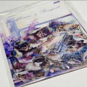 May include: A package of stickers featuring watercolor illustrations of kittens amidst purple flowers and a window scene. The text "Windflower & Pussycat" is visible at the top. The stickers are in a clear plastic sleeve.
