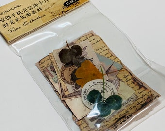 May include: A clear plastic package containing decorative paper ephemera. The ephemera includes vintage-style paper with text, stamps, and botanical elements. The package has text in Chinese and English, including "Time Collection."