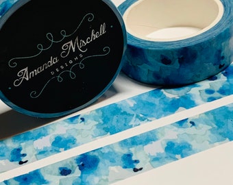 May include: Blue watercolor washi tape with a white background. The tape is rolled up and the label reads "Amanda Mischell Designs".