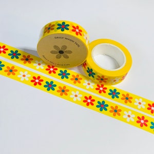 Pu&ograve; includere: Due rotoli di nastro washi giallo con un motivo a margherita. Il nastro &egrave; 15 mm x 10 m e privo di acidi. Il testo "Daisy Washi Tape" &egrave; stampato sul rotolo.