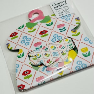 May include: A package of sticker flakes with a floral pattern. The stickers are shaped like a dress and feature a repeating design of red, pink, yellow, and blue flowers on a white background. The package includes a label that reads "Charmy pattern Sticker flakes".