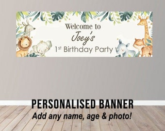 May include: A personalized banner with a jungle theme. It features a giraffe, lion, elephant, and rhino with green leaves and gold stars. The text reads "Welcome to Joey's 1st Birthday Party".