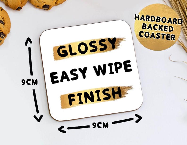 May include: Square white coaster with the words "GLOSSY EASY WIPE FINISH" in black text. The coaster is 9cm x 9cm and has a gold-colored brushstroke design. The coaster is labeled "HARDBOARD BACKED COASTER".