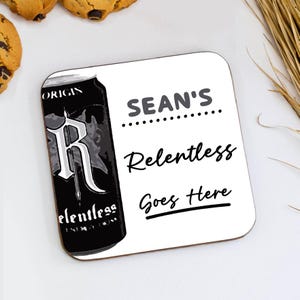 May include: Square white coaster with the text "SEAN'S Relentless Goes Here". The coaster features a black and grey image of a can of "Relentless" energy drink. Chocolate chip biscuits and wheat stalks are in the background.