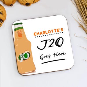 May include: Square coaster with a white background and a graphic of a J2O bottle. The coaster has the text "CHARLOTTE'S J2O Goes Here" in orange and black. The J2O bottle is orange and green.