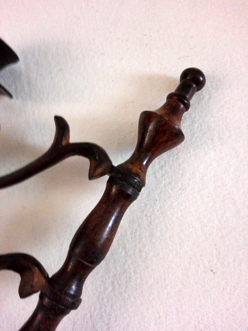 May include: A close-up of a wooden pipe with a dark brown finish. The pipe has a decorative design and a round mouthpiece.