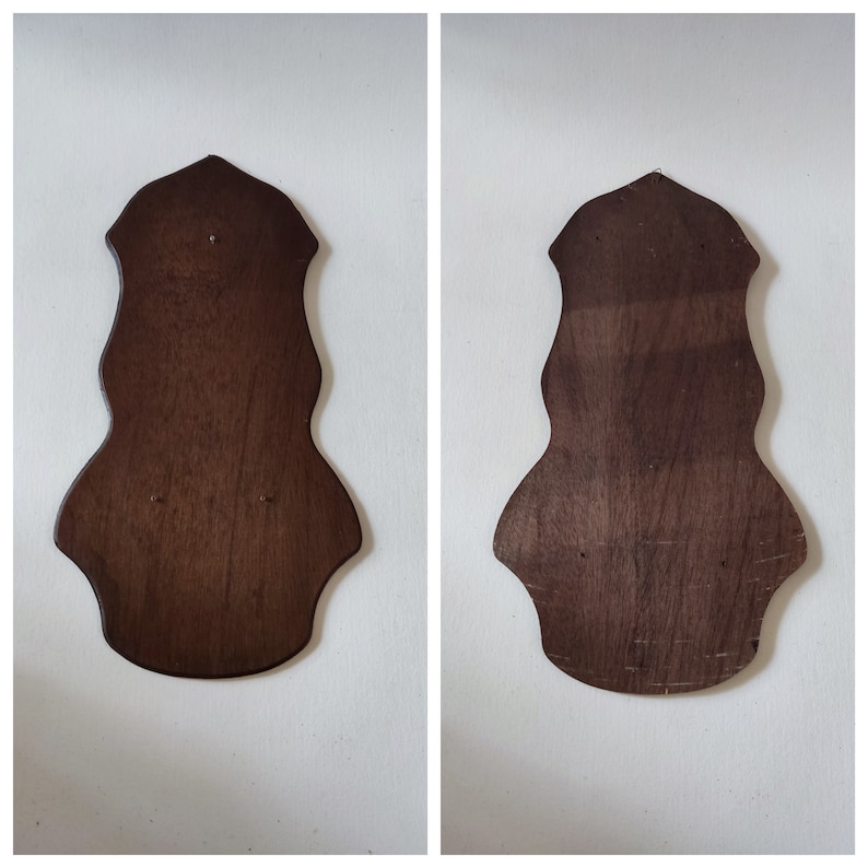 May include: Two dark brown wooden wall-mounted plaques with a scalloped edge. The plaques are blank and ready to be decorated.