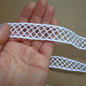 May include: White cotton lace trim with a diamond pattern. The lace is approximately 1 inch wide.