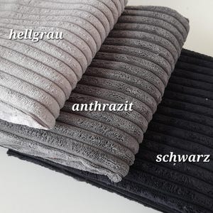 Könnte beinhalten: Drei Stoffmuster in verschiedenen Grautönen: hellgrau, anthrazit und schwarz. Die Muster sind mit "hellgrau", "anthrazit" und "schwarz" beschriftet.